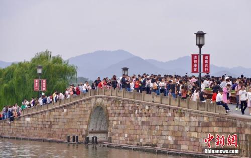 10月3日,国庆长假第三天,大量游客涌入西湖断桥。 中新社记者 李晨韵 摄