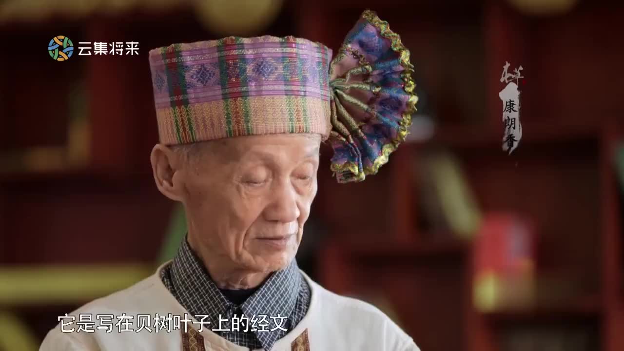 年近80岁的傣医康朗香正在翻阅着贝叶经