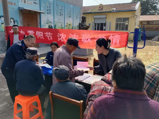 图：在重阳节活动期间向村民介绍银龄安康保险