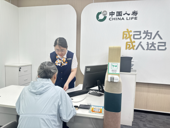 图：工作人员为老年客户介绍银龄安康保险