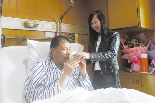 图为妻子周云花在细心照顾屠文耀.