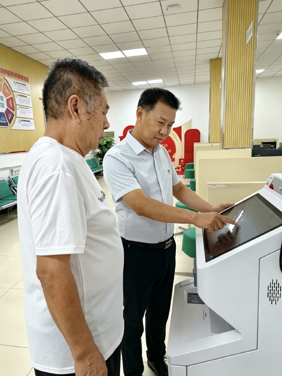 图：营销员党员张小刚为客户办理保单查询业务